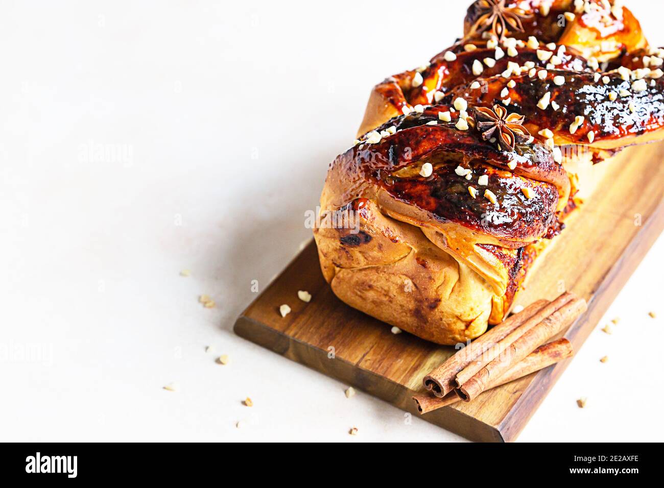 Babka oder Brioche Brot mit Aprikosenmarmelade und Nüssen. Hausgemachtes Gebäck zum Frühstück. Konkreter Hintergrund. Selektiver Fokus. Stockfoto