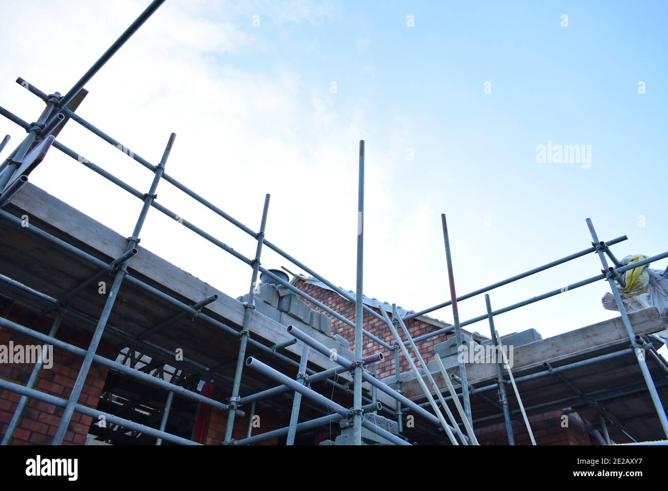 Nahaufnahme von Gerüsten auf einem Haus auf der Baustelle Draußen an einem sonnigen Tag im Winter mit blauem Himmel Stockfoto