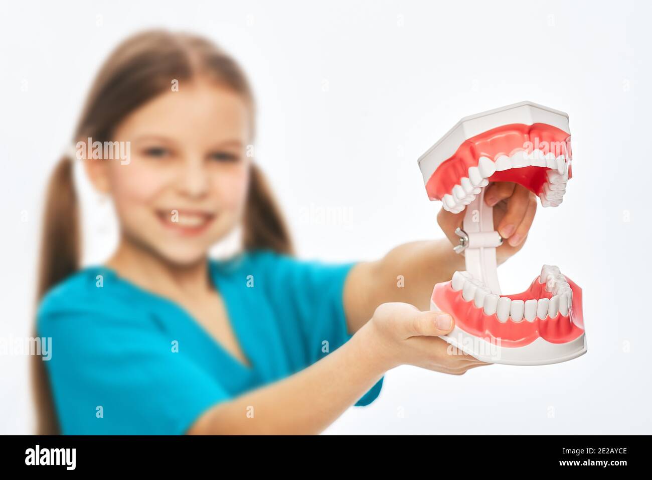 Nettes Mädchen spielen Zahnarzt, hält ein Spielzeug Modell Kiefer für Studie. Kinderhobby und zukünftige medizinische Beschäftigung Stockfoto