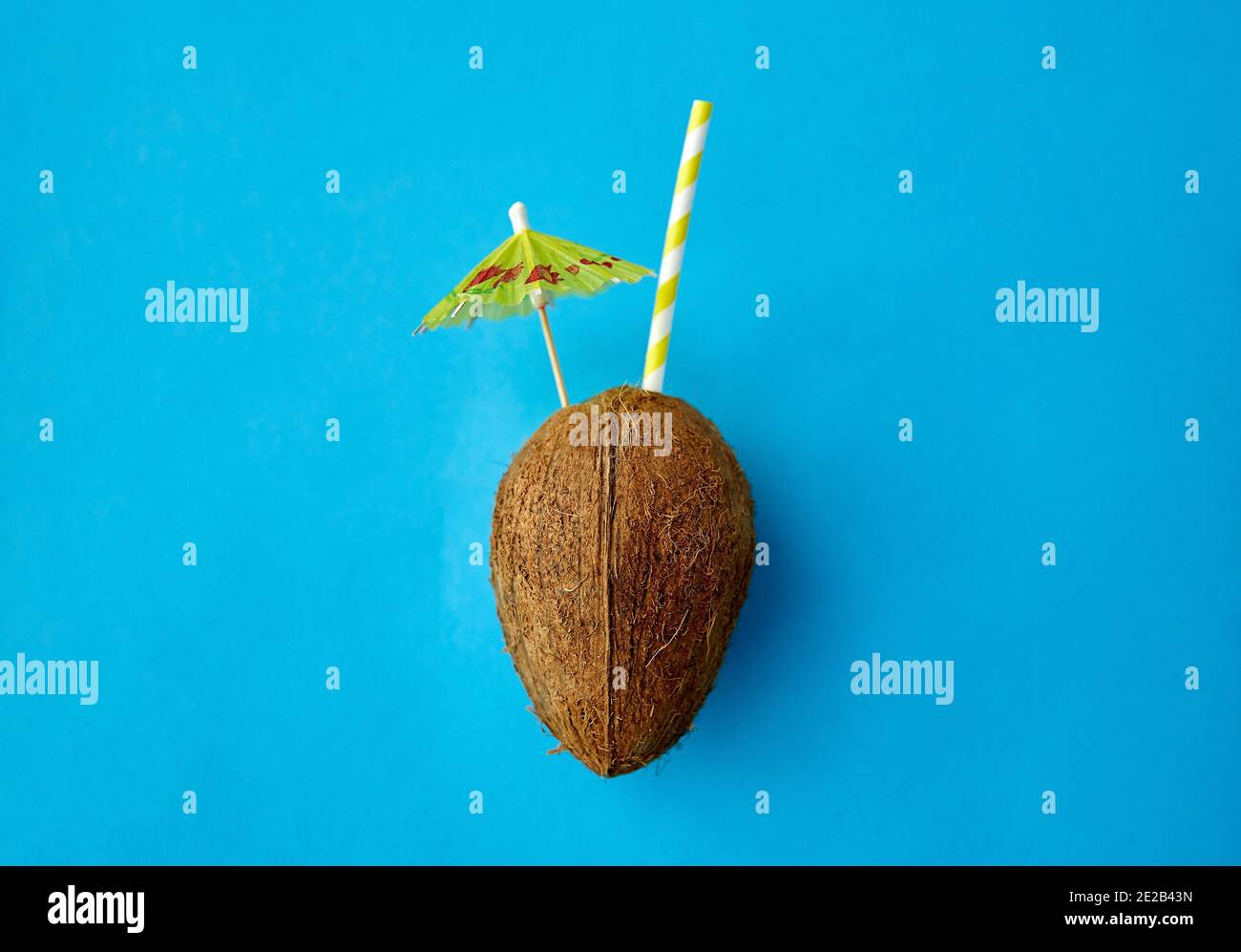 Kokosnussgetränk mit Stroh und Cocktailschirm Stockfoto