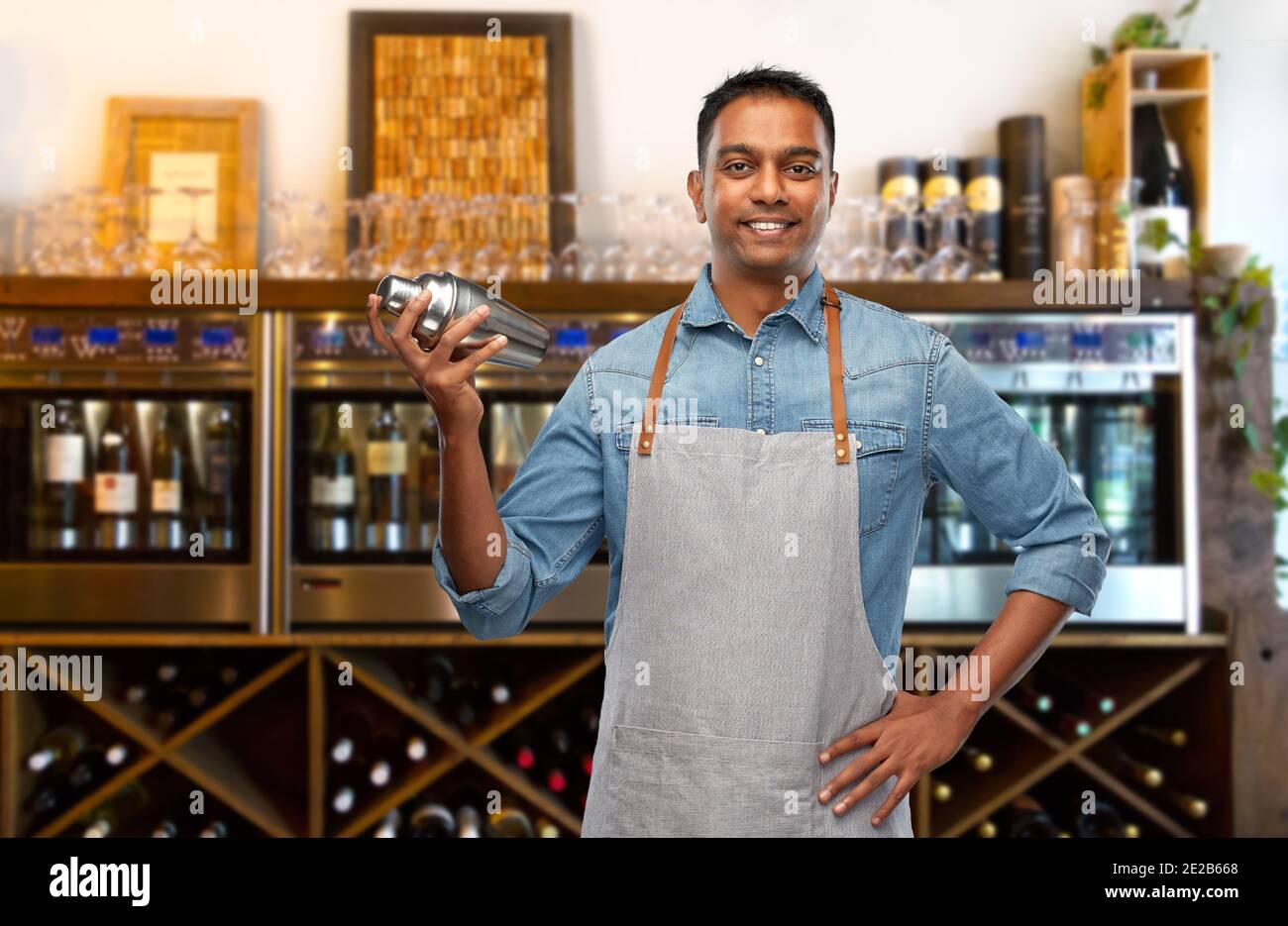 indischer Barkeeper im Vorfeld mit Cocktail Shaker an der Bar Stockfoto