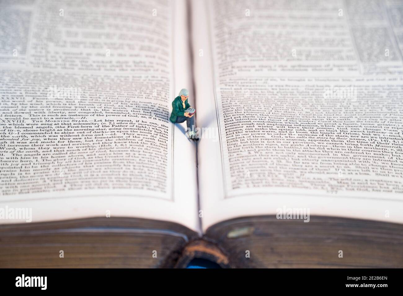 Modell Figur saß Lesung zwischen den Seiten der Bibel. Januar 2021 Stockfoto