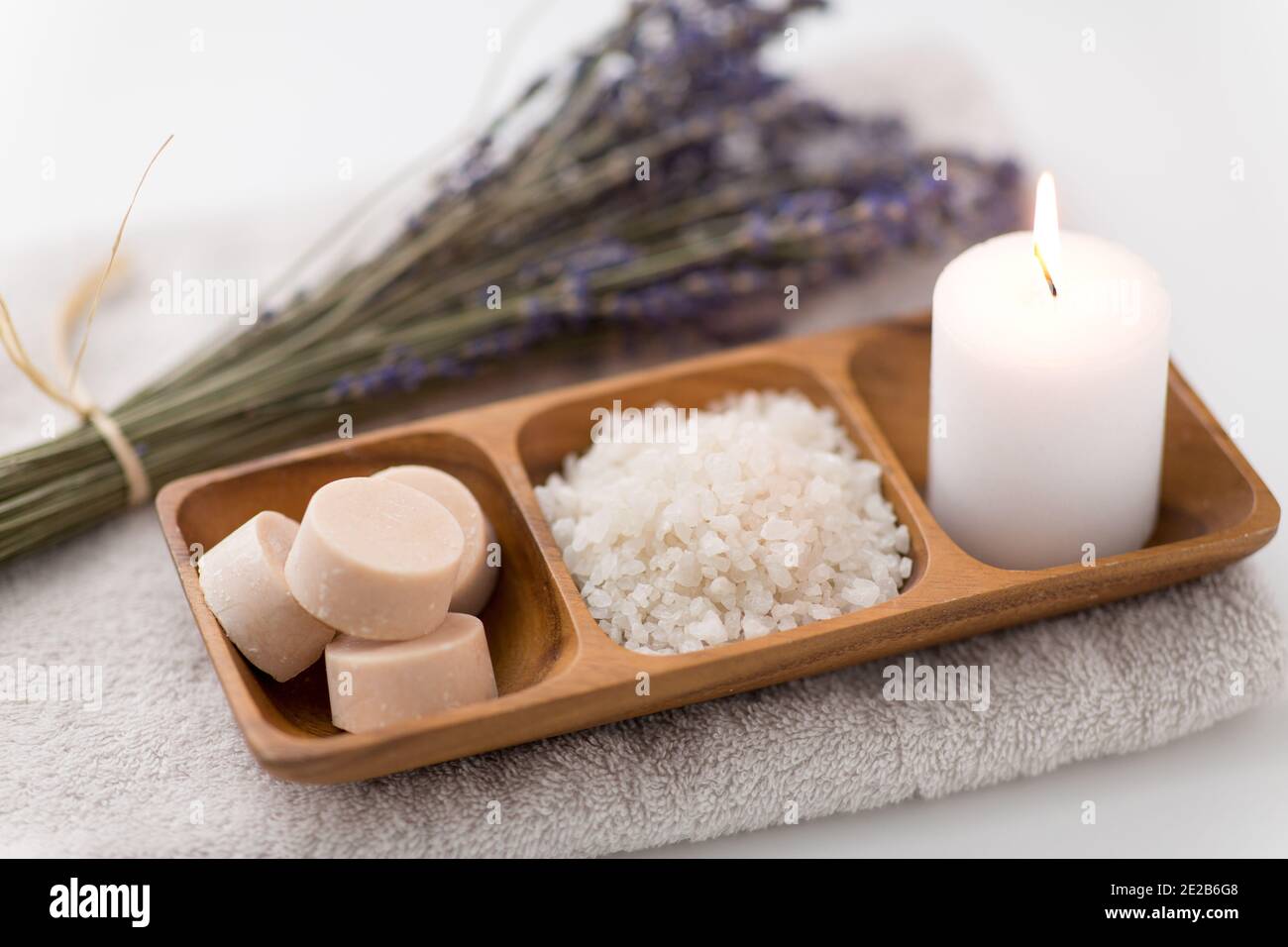 Meersalz, Seife, Kerze und Lavendel auf Badetuch Stockfoto