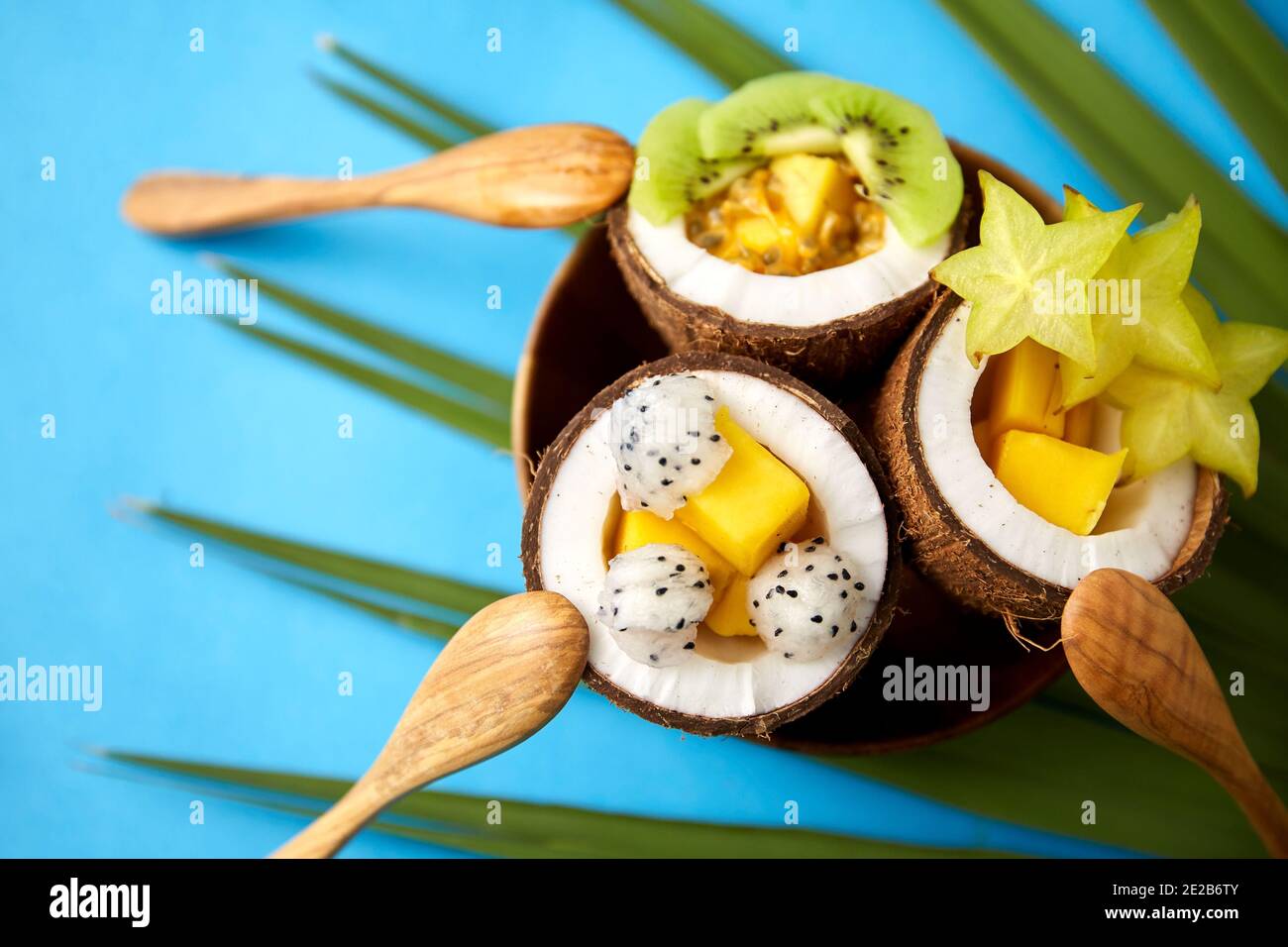 Mischung aus exotischen Früchten in Kokosnussschalen mit Löffeln Stockfoto