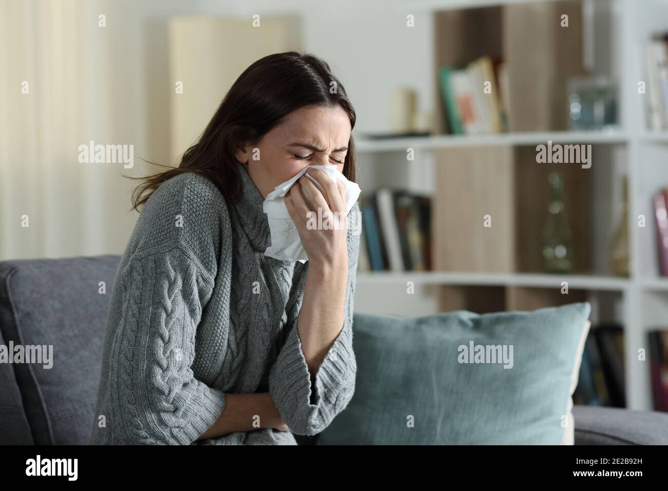 Kranke Frau mit Grippe-Symptome Blasen auf Tuch sitzen auf Eine Couch zu Hause Stockfoto