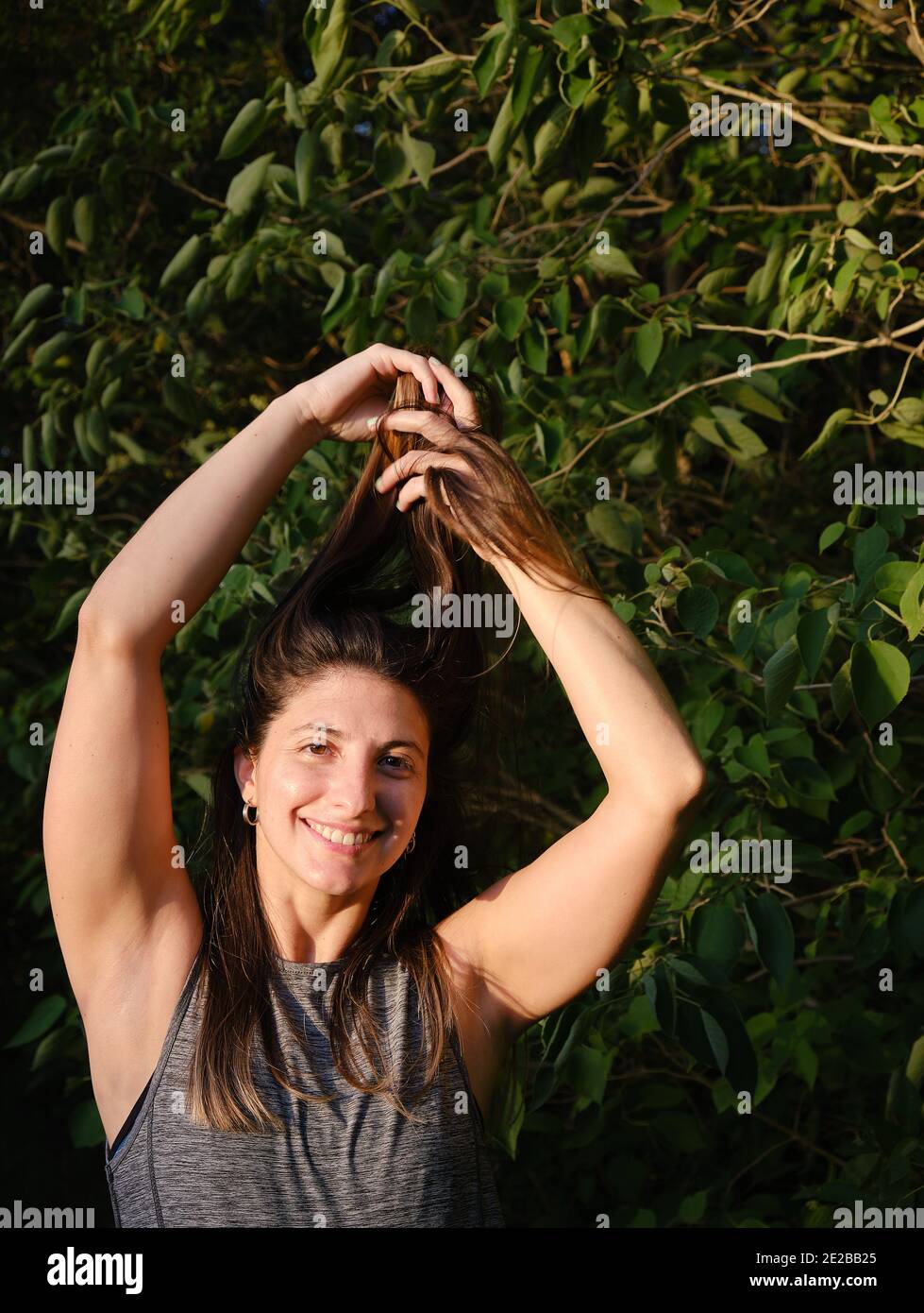 Ein Porträt einer Frau, die sich die Haare einreibt Der Wald Stockfoto