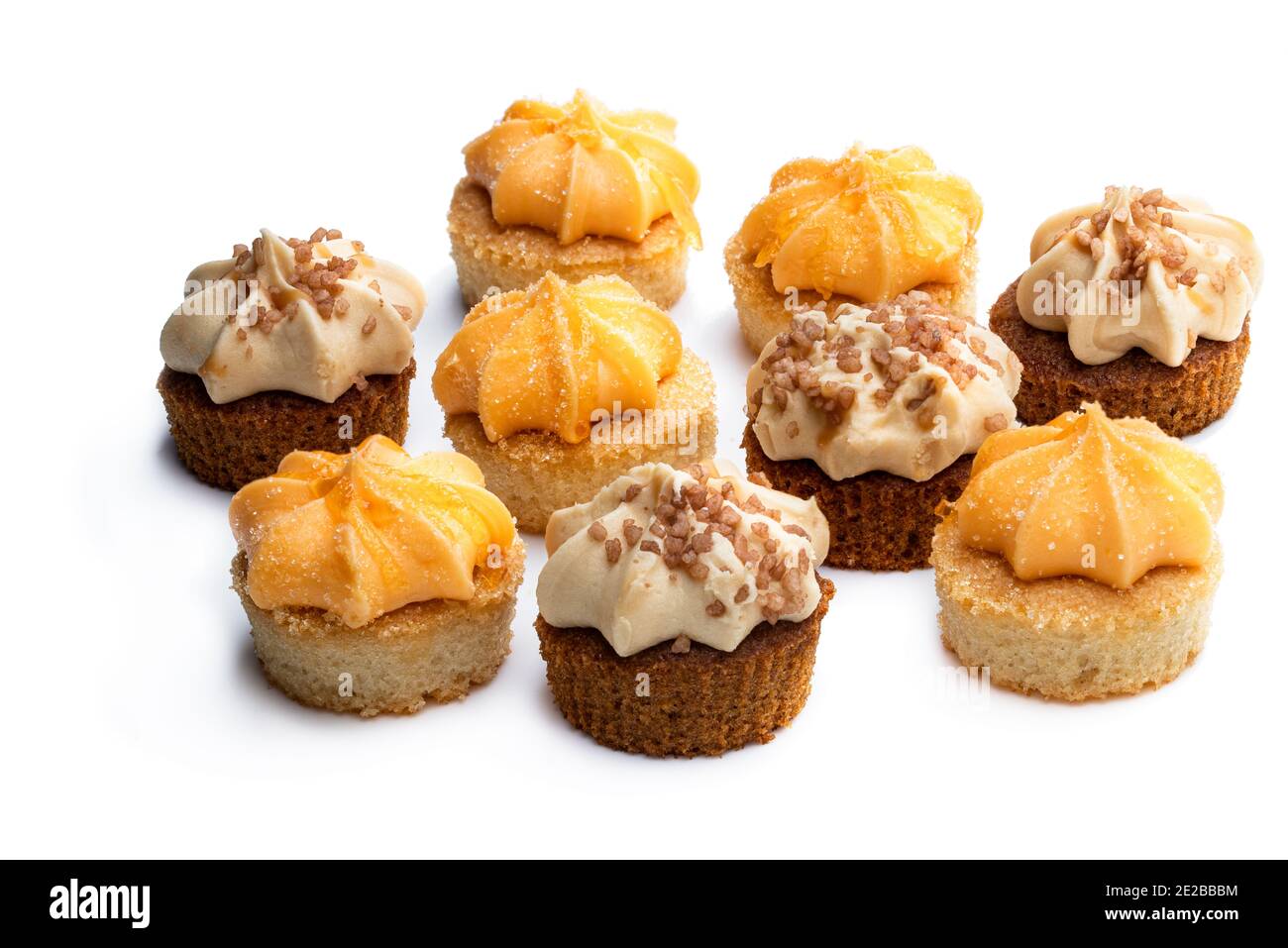 Mini Biskuit Kuchen mit Orange und Karamell Buttercreme garniert isoliert Auf Weiß Stockfoto