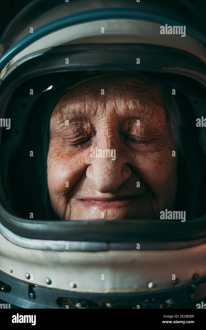 Filmisches Porträt eines alten Astronauten, der nach Hause kommt. Großmutter mit Vintage Raumanzug. Fiktion Konzept über Weltraumforschung und Wissenschaft Stockfoto