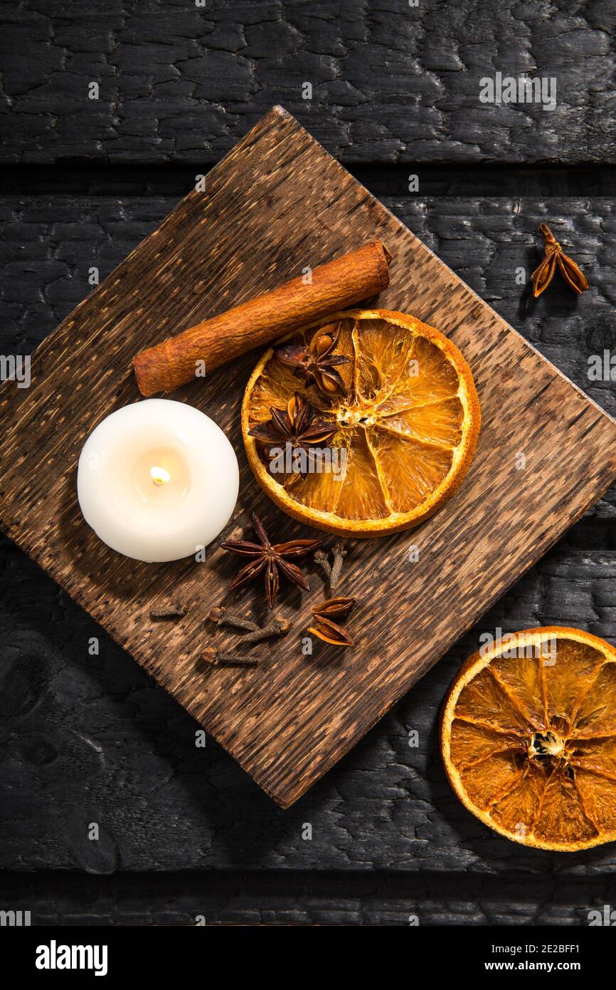 Winter Gewürzkonzept. Flache Ansicht verschiedener Gewürze: Zimtstange, Nelke, Sternanis, getrocknete Orangenscheiben. Holzplatte mit saisonalen Potpourri. Stockfoto