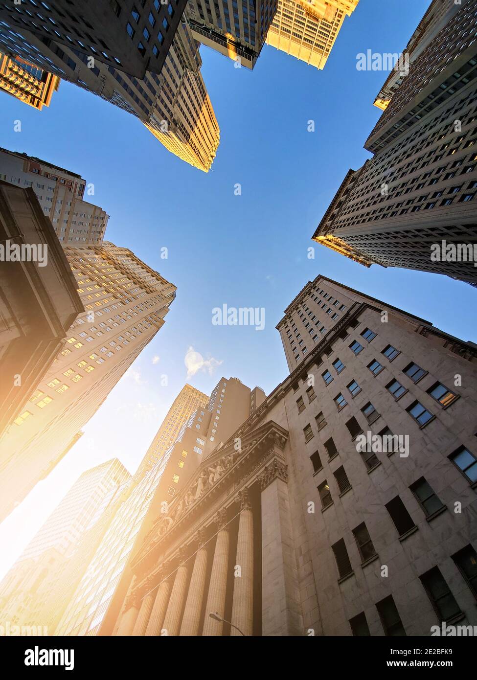 Gebäude der Wall Street, die sich über einem blauen Himmel erheben Hintergrund im historischen Finanzviertel von Lower Manhattan in New York City Stockfoto