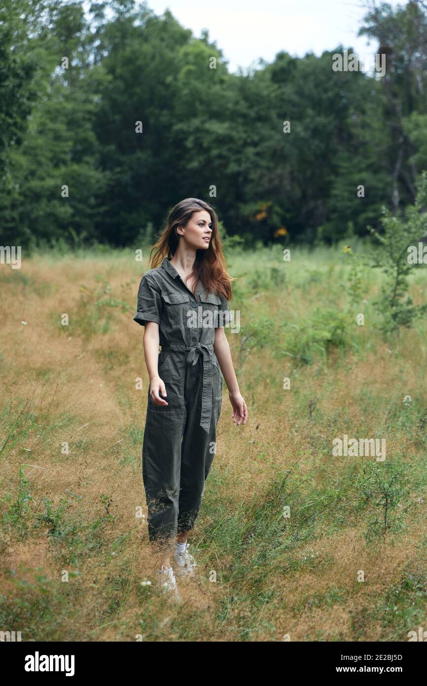 Frau im Wald in der Wiese grau Jumpsuit Stockfoto