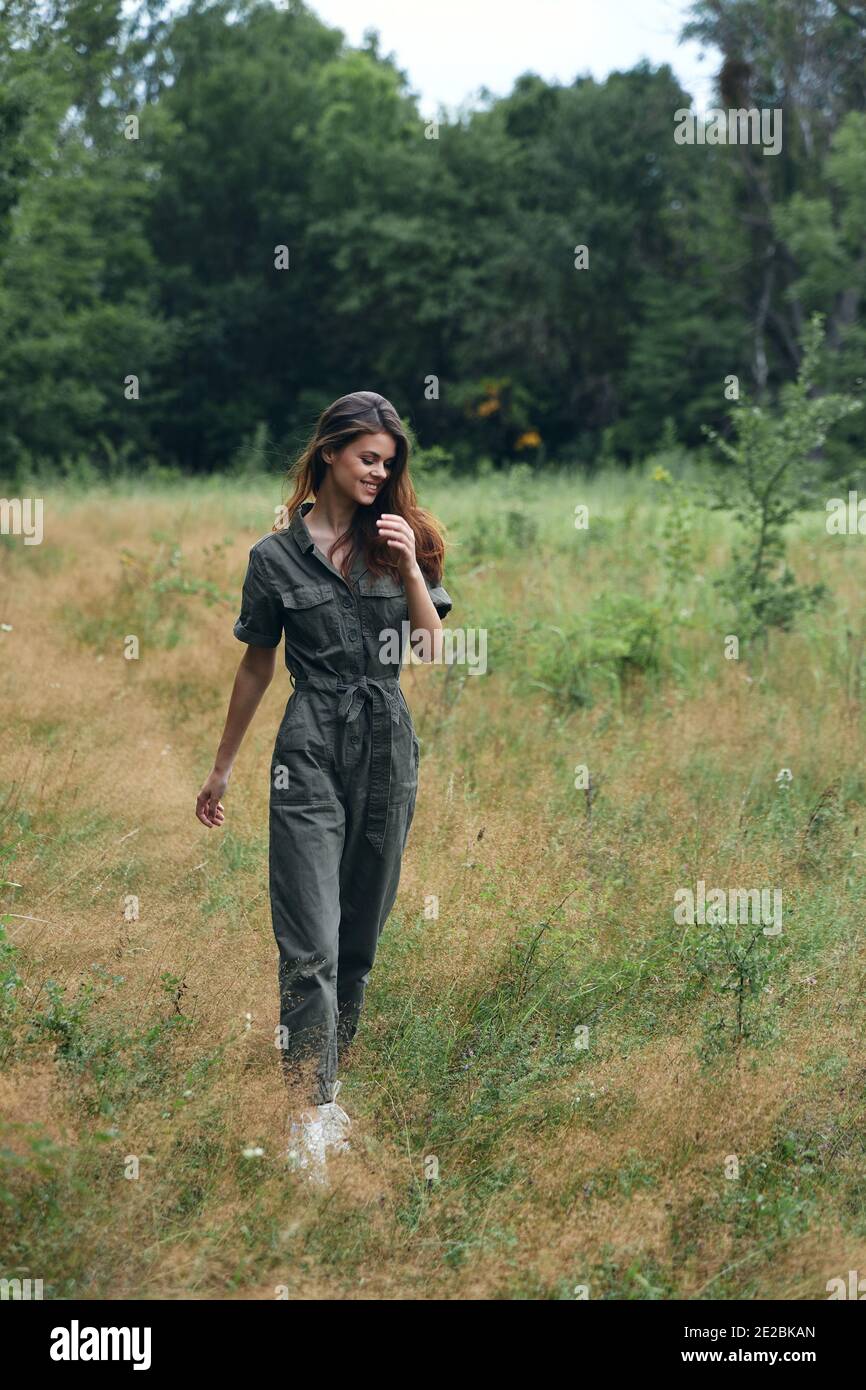 Frau im Wald zu Fuß durch das Feld rote Haare Grüner Anzug Stockfoto
