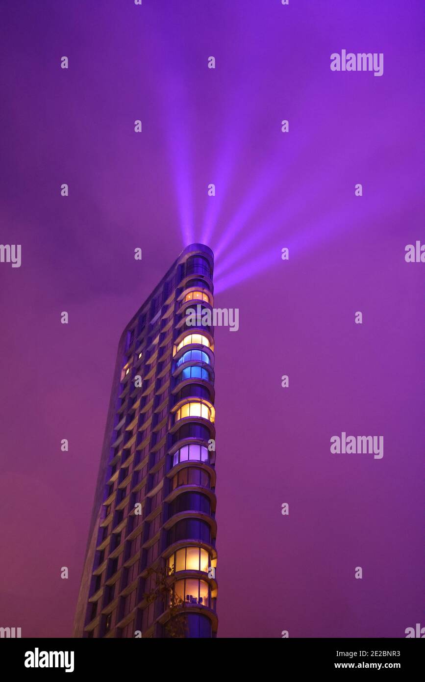 Hochhaus in Eindhoven während der Sonderausgabe des GLOW-Festivals mit Lichtstrahlen und einem blau beleuchteten Himmel; größtes Lichtkunstwerk aller Zeiten Stockfoto