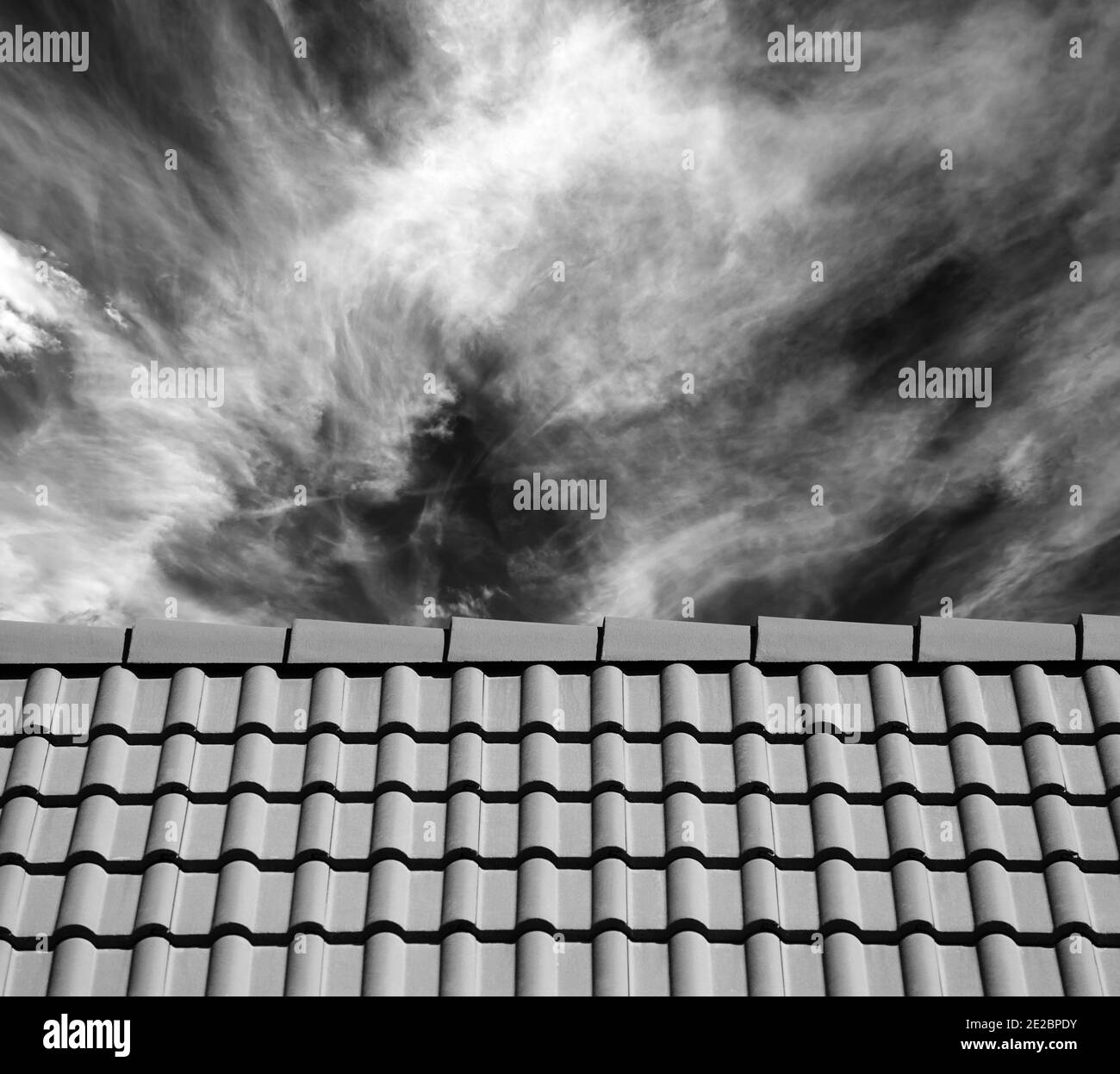 Dachziegel und Himmel mit Wolken am Sonnentag. Schwarzweißbild. Stockfoto