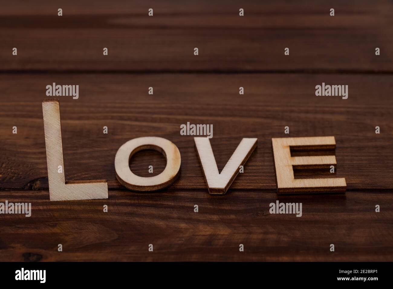 Love Lettering Holzbuchstaben auf Holzhintergrund mit Kopierraum. Stockfoto