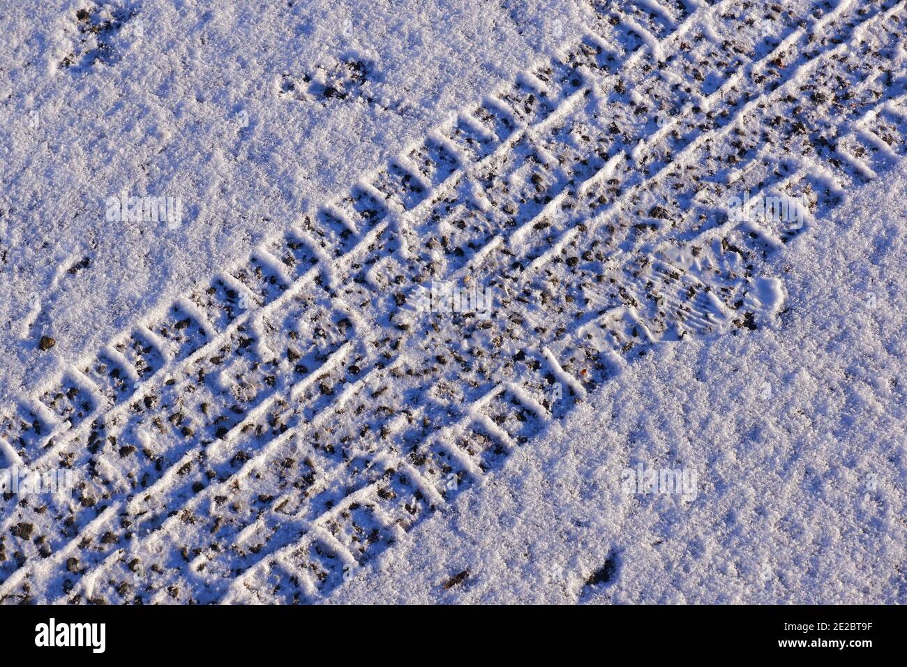 Autoradbahn im Schnee auf der Straße Stockfoto