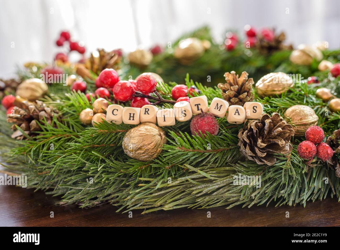 Schöner Weihnachtskranz mit 'Weihnachten' Buchstaben, saftige Farben Stockfoto