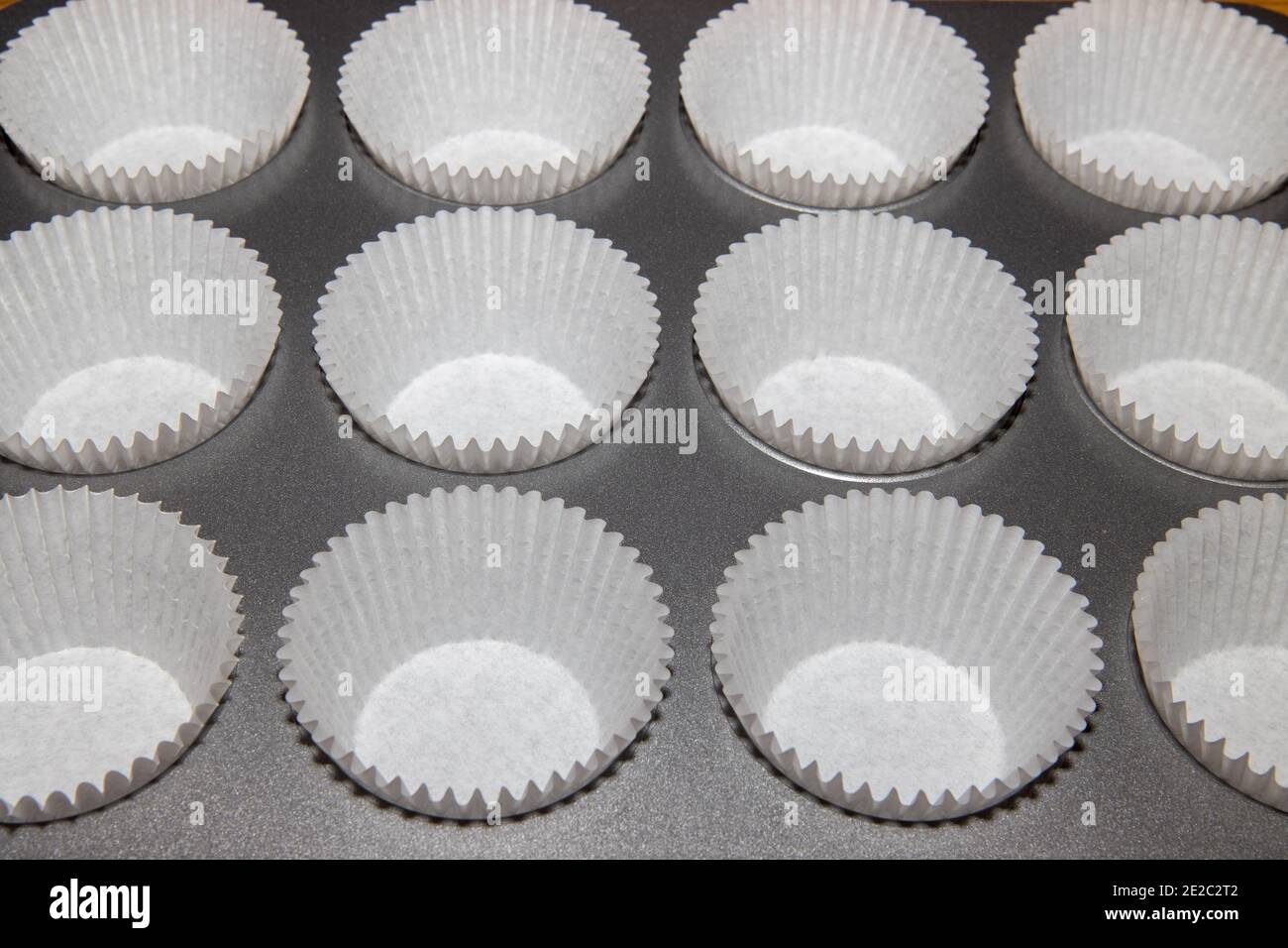 Ein Metall-Backblech füllen von Tasse Kuchen Halter bereit In etwas Kuchenmischung gegeben werden Stockfoto