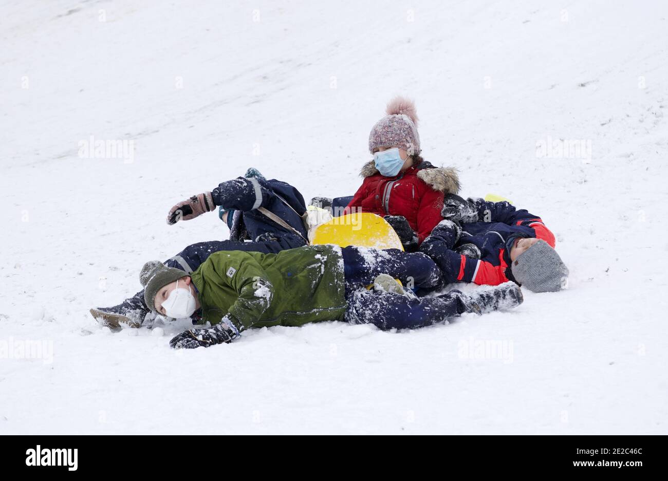 Gruppe von Kindern, die im Winter auf dem Schnee spielen. Stockfoto