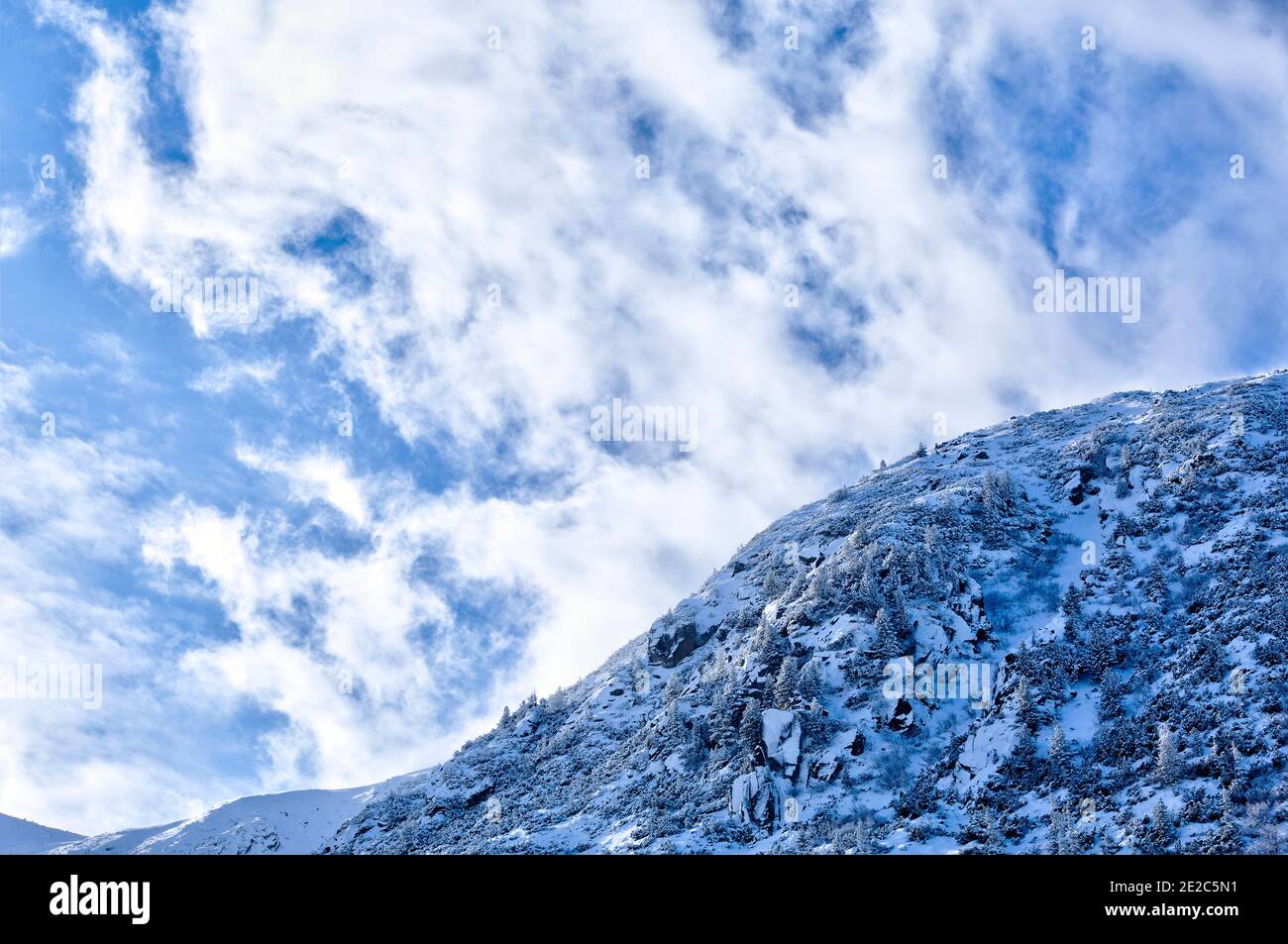 Alpine Landschaft mit Schnee und dramatischer Wolkenlandschaft auf den Retezat Bergen. Foto aufgenommen am 2. Februar 2020 im Retezat Nationalpark, Rumänien. Stockfoto