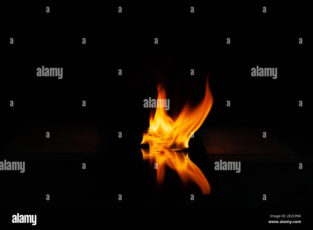 Feuerflamme mit Spiegelung im Glas auf einem schwarzen Hintergrund Stockfoto