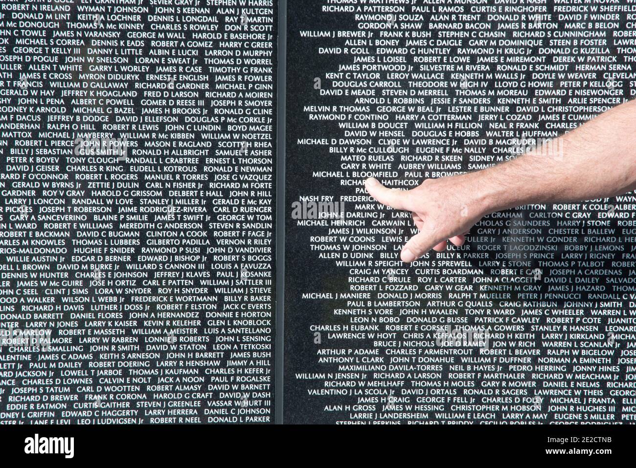Ein Finger zeigt auf einige der Namen auf der Vietnam-Mauer in Punta Gorda, Florida Stockfoto