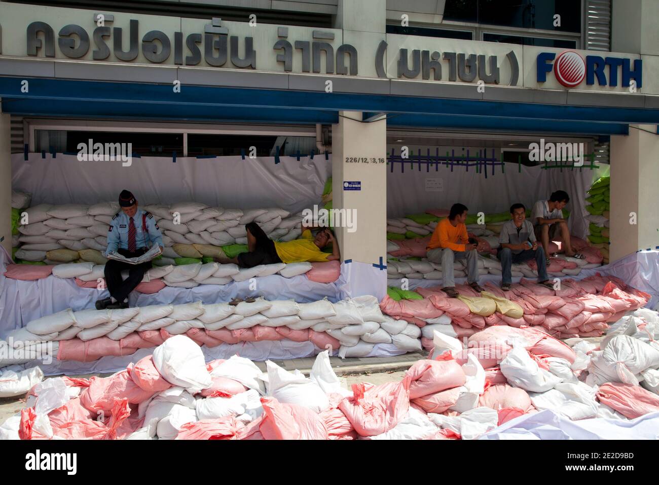 Mitarbeiter nehmen am 31. Oktober 2011 in ihrem geschlossenen vierten Geschäft auf der Straße nach Phahon Yothin in Bangkok, Thailand, Zuflucht. Thailand erlebt die schlimmsten Überschwemmungen seit über 50 Jahren, von denen mehr als neun Millionen Menschen betroffen sind. Nach Angaben des Department of Disaster Prevention and Mitigation sind seit Ende Juli mehr als 400 Menschen bei Hochwasserereignissen ums Leben gekommen. Foto von Frederic Belge/ABACAPRESS.COM Stockfoto