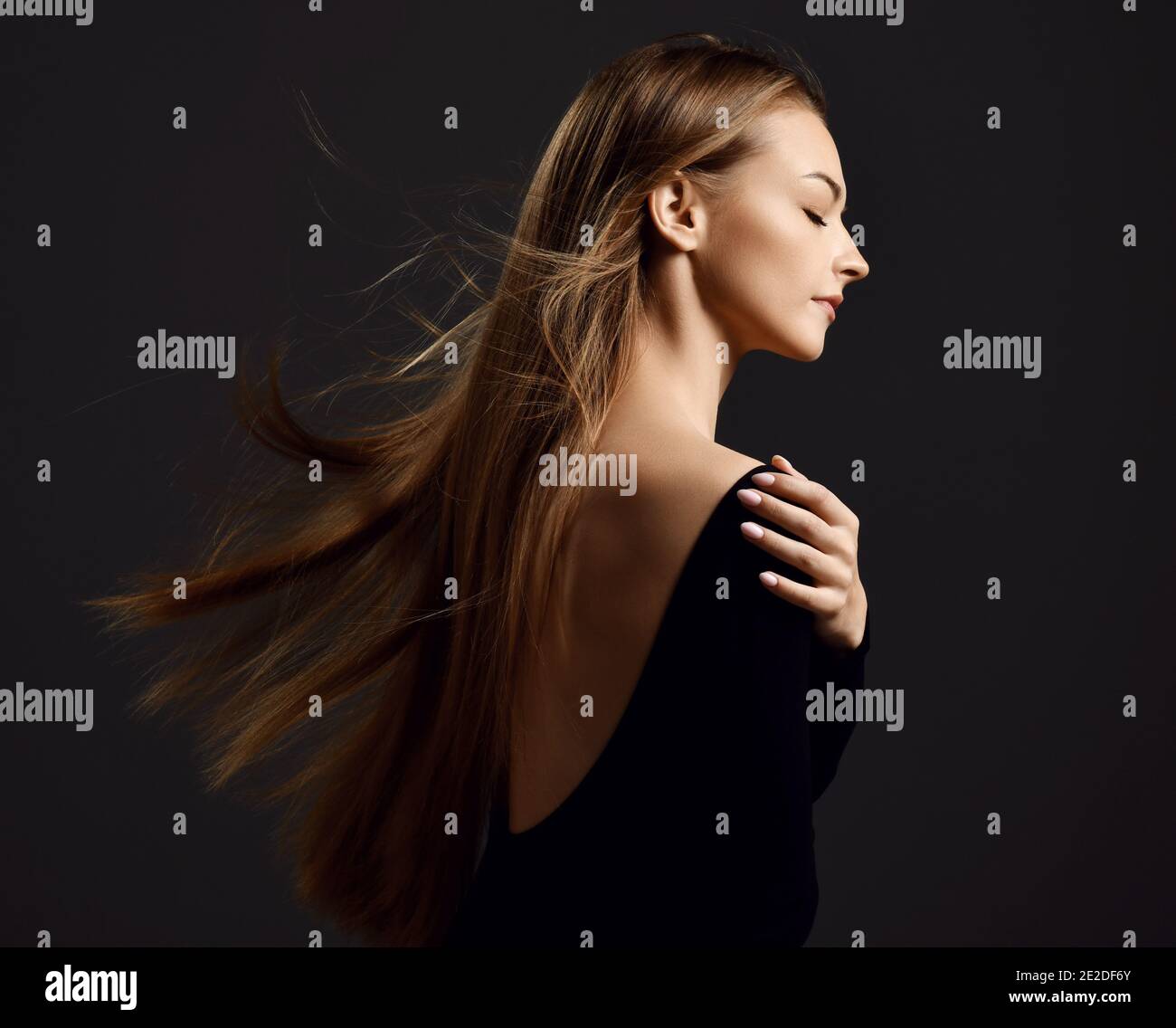 Profil von jungen schönen Frau mit langen seidigen geraden Fliegen Haare in schwarzem Körper mit geschlossenen Augen Stockfoto