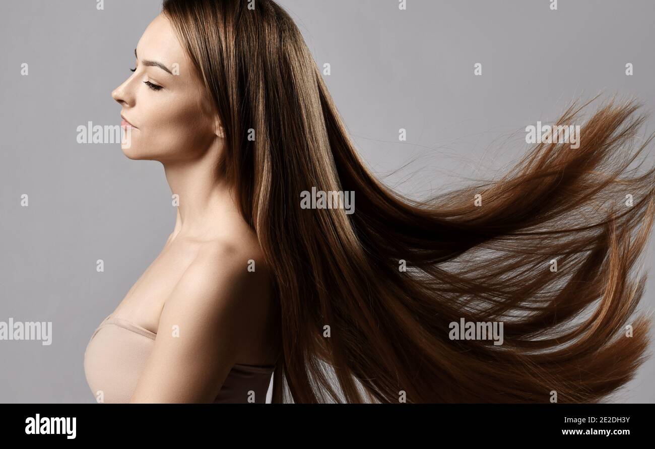 Profil der jungen Frau mit engen Top-BH mit geschlossen Augen und lange seidig gerade Haare fliegen flatternd in der Wind Stockfoto