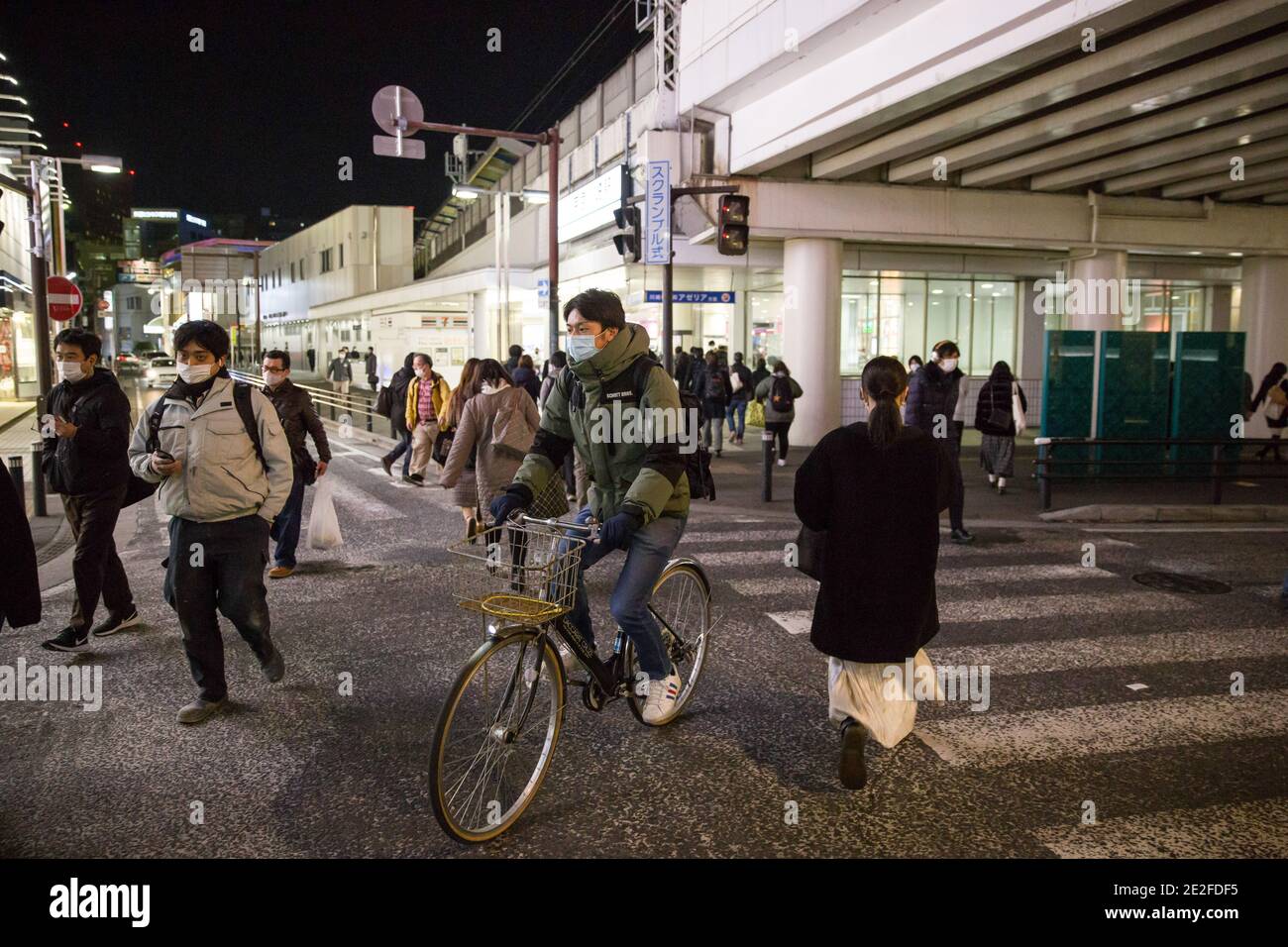 Kawasaki, Japan. Januar 2021. Ein Mann auf einem Fahrrad, der eine Gesichtsmask in der Nähe der Keikyu Kawasaki Station trägt. Kredit: SOPA Images Limited/Alamy Live Nachrichten Stockfoto