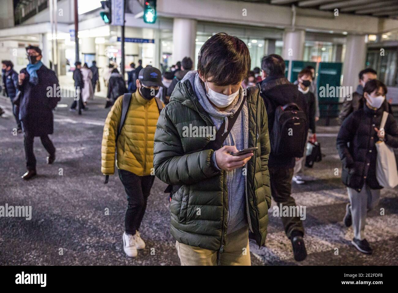 Kawasaki, Japan. Januar 2021. Fußgänger mit Gesichtsmasken überqueren die Straße in der Nähe der Keikyu Kawasaki Station. Kredit: SOPA Images Limited/Alamy Live Nachrichten Stockfoto