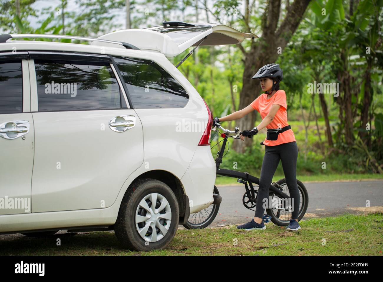 Asiatische Frau, die fertig Radfahren im Freien und laden Die Fahrräder ins  Auto Stockfotografie - Alamy
