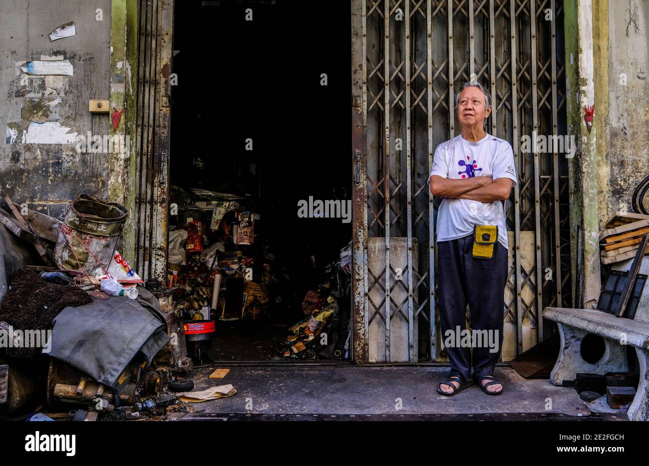 Ein Mann steht vor seinem Schrottmetallgelände in Chinatown, Bangkok, Thailand Stockfoto