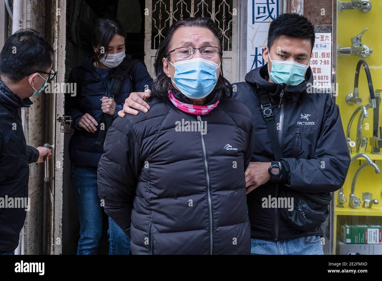 Hongkong, China. Januar 2021. Bezirksrat und Rechtsanwalt Daniel Wong Kwok-tung wird von Polizisten begleitet, als er sein Büro verlässt. Wong wurde Berichten zufolge von Polizeibeamten der nationalen Sicherheit verhaftet, weil sie zwölf Demonstranten in Hongkong bei ihrem Versuch, im vergangenen August nach Taiwan zu fliehen, mitgemacht hatten. Kredit: SOPA Images Limited/Alamy Live Nachrichten Stockfoto