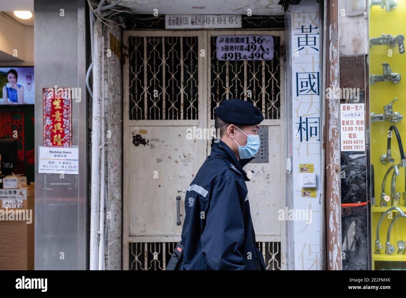 Hongkong, China. Januar 2021. Ein Polizeibeamter steht Wache vor dem Büro des Bezirksrates und Anwalts Daniel Wong Kwok-tung. Wong wurde Berichten zufolge von Polizeibeamten der nationalen Sicherheit verhaftet, weil sie zwölf Demonstranten in Hongkong bei ihrem Versuch, im vergangenen August nach Taiwan zu fliehen, mitgemacht hatten. Kredit: SOPA Images Limited/Alamy Live Nachrichten Stockfoto