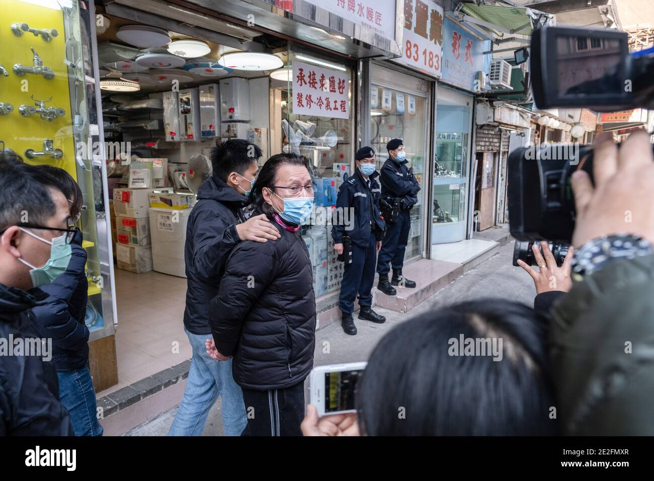Hongkong, China. Januar 2021. Bezirksrat und Rechtsanwalt Daniel Wong Kwok-tung wird von Polizisten begleitet, als er sein Büro verlässt. Wong wurde Berichten zufolge von Polizeibeamten der nationalen Sicherheit verhaftet, weil sie zwölf Demonstranten in Hongkong bei ihrem Versuch, im vergangenen August nach Taiwan zu fliehen, mitgemacht hatten. Kredit: SOPA Images Limited/Alamy Live Nachrichten Stockfoto