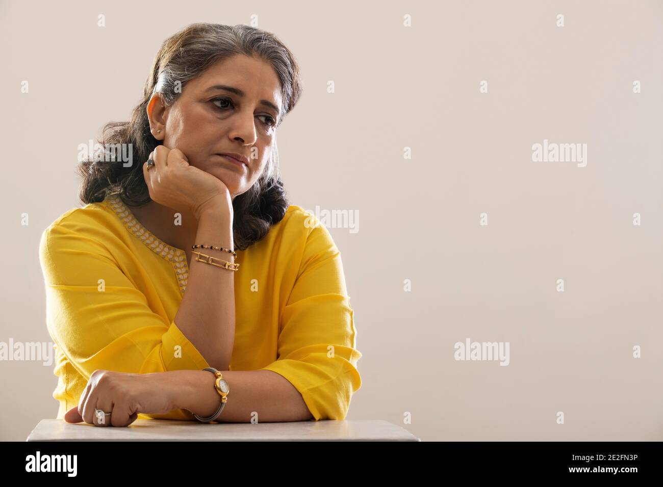 EINE ÄLTERE ERWACHSENE FRAU SITZT UND DENKT Stockfoto