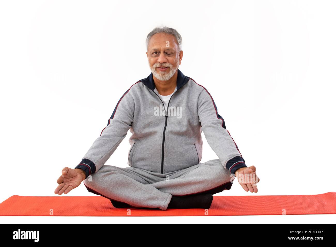 EIN ALTER MANN WINKEND, DER YOGA ASANA MACHT Stockfoto