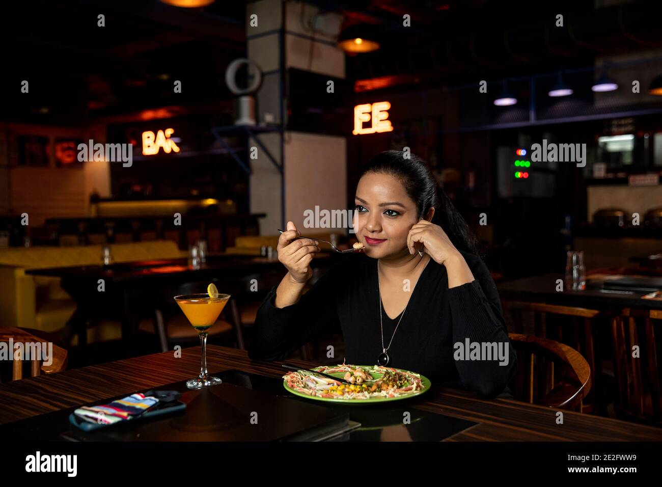 Portrait einer hübschen Frau, die in einem Restaurant leckeres Essen isst. Stockfoto