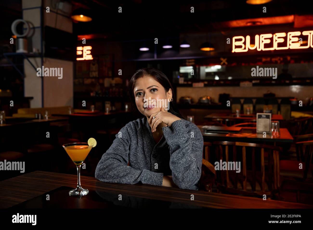 Porträt einer Frau mit einem Glas Saft in einem Restaurant. Stockfoto
