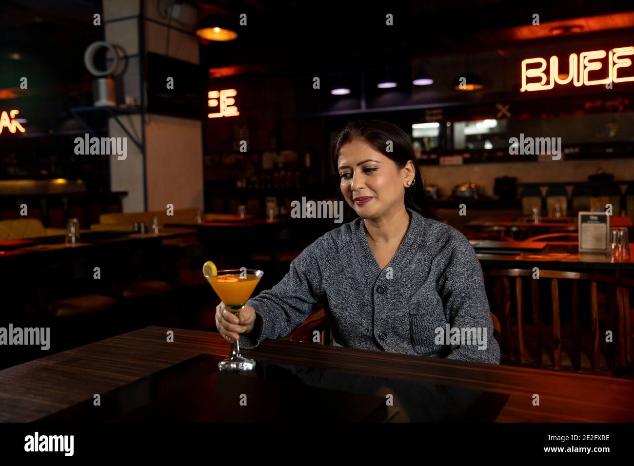 Porträt einer Frau mit einem Glas Saft in einem Restaurant. Stockfoto