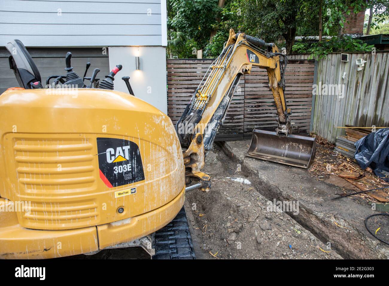 Mini Bagger graben einen Graben, um Reparatur von gebrochen zugreifen Regenwasserleitung, Sydney, Australien Stockfoto