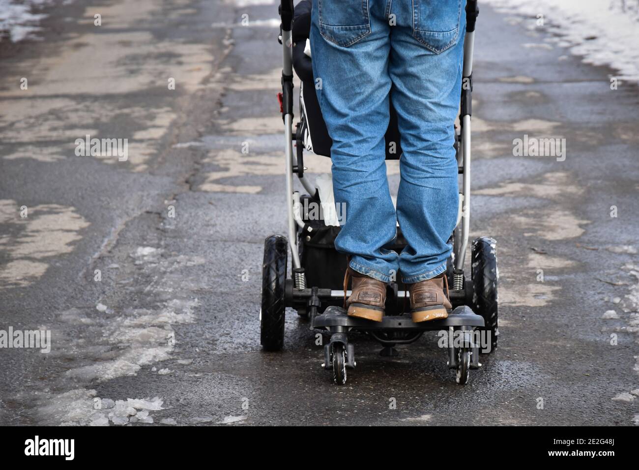 Rückansicht des Mannes, der auf dem Troller-Brett für fährt Kinder und Spaß  haben - das Konzept des glücklichen Vaters Stockfotografie - Alamy