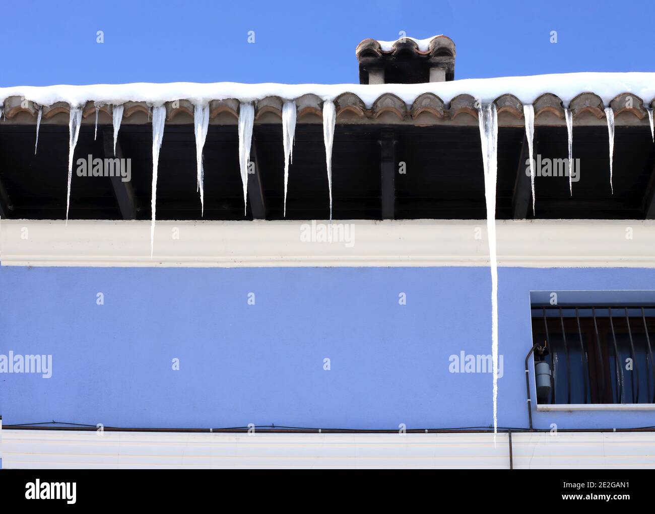 Eiszapfen auf der hübschen Kante eines Daches Stockfoto