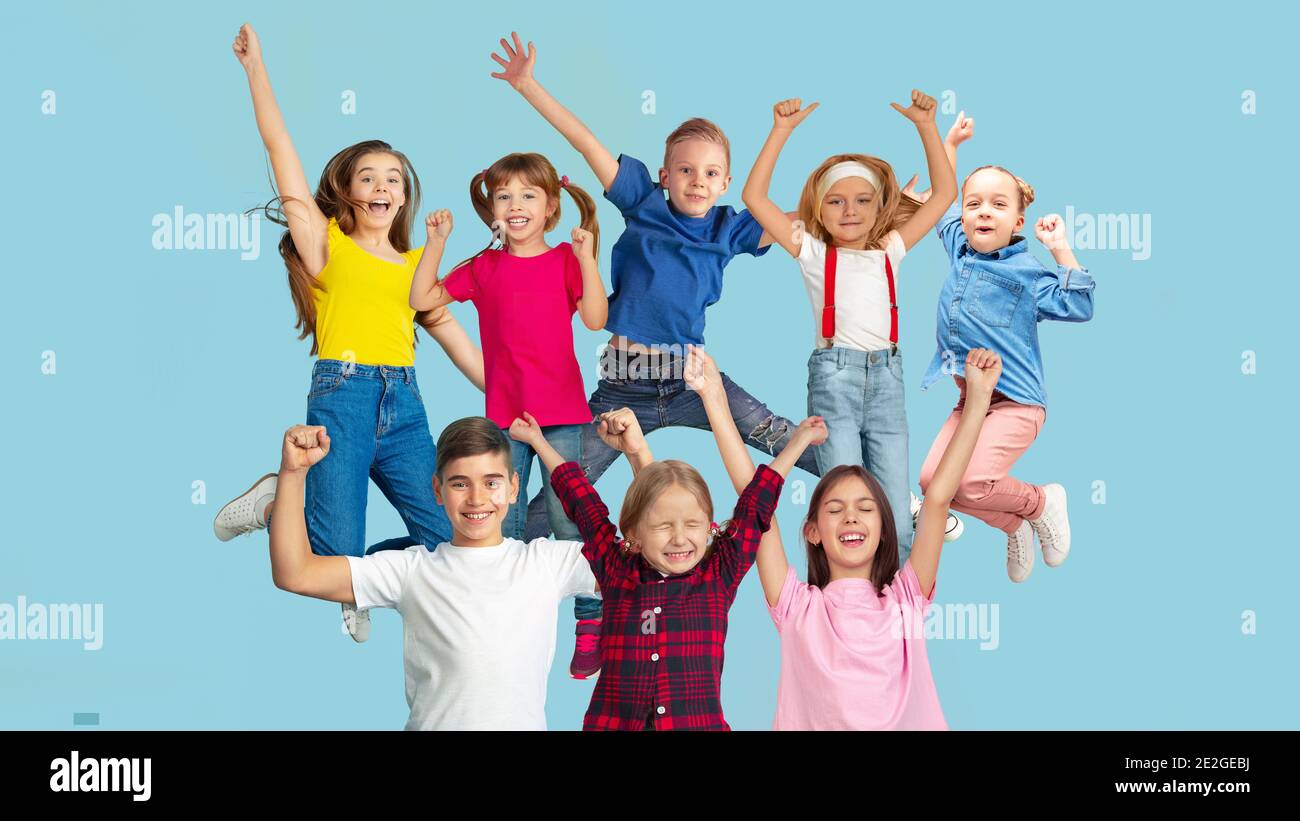 Glücklich. Porträt von kleinen kaukasischen Kindern springen isoliert auf blauem Studio-Hintergrund mit Copyspace. Fröhliche Kindermodelle. Konzept der menschlichen Emotionen, Gesichtsausdruck, Verkauf, Anzeige, Kindheit. Stockfoto