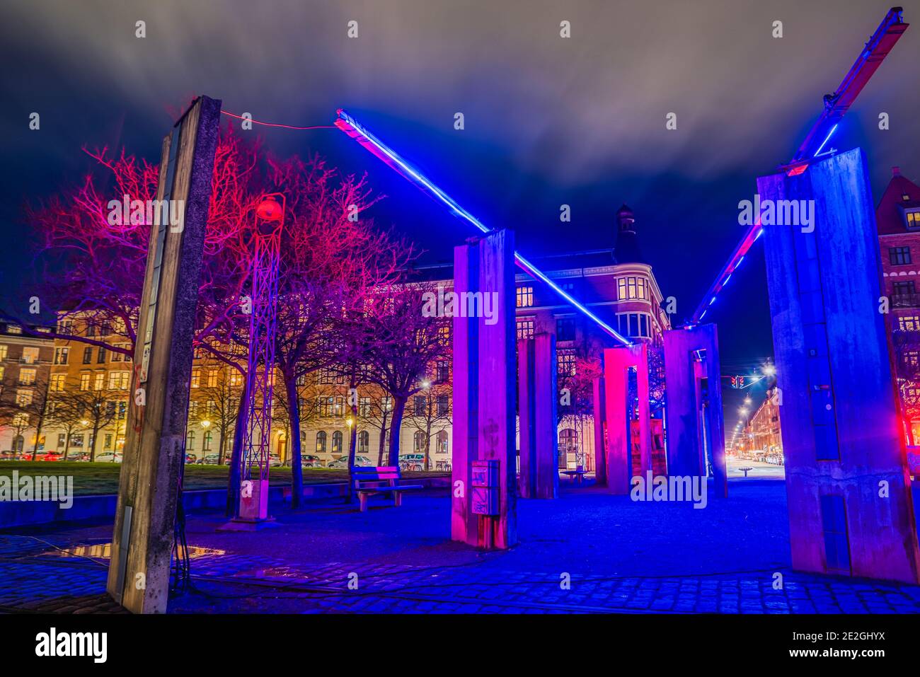 Nächtliche Darstellung der Industriegeschichte des Wohnviertels Von Inseln Brygge mit Monolithen beleuchtet von einem blauen hellen Leicht Stockfoto