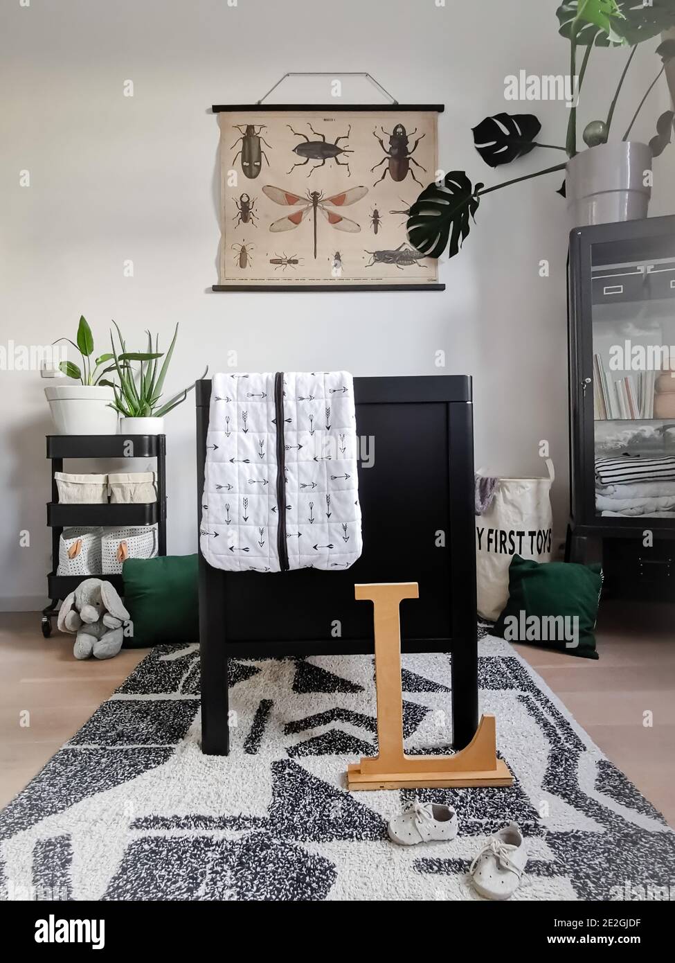 Moderne schwarz-weiße Babykrippe mit einem Naturthema mit Pflanzen und Dschungel Dekoration. Stockfoto