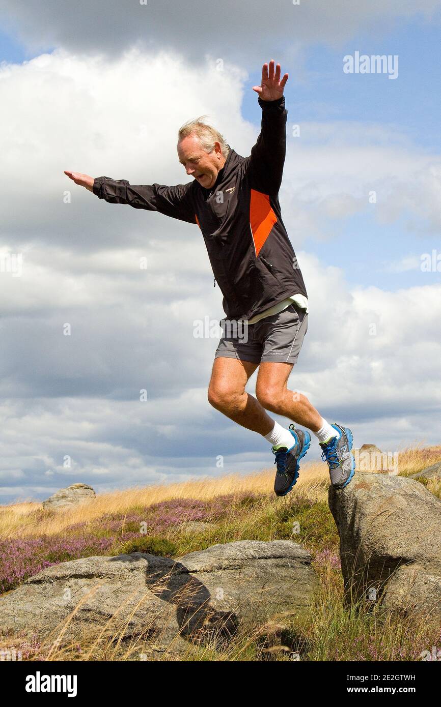 Mann springt von Felsen Stockfoto