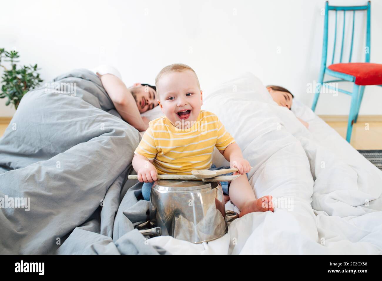 Kleinkind trommelt laut auf Töpfe, die Eltern nicht erlauben zu schlafen Stockfoto