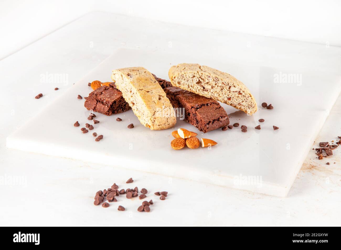 Biscotti-Kekse mit Mandelschokolade und Zutaten auf weißer Marmorplatte Stockfoto